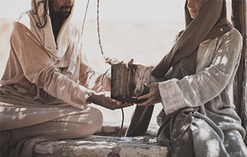 The Samaritan woman giving Jesus a drink of water from the well