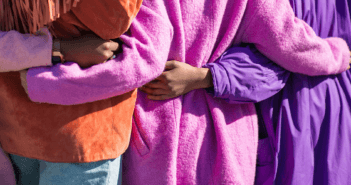 People being welcomed while wearing coats in Easter colors