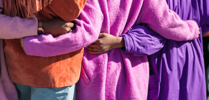 People being welcomed while wearing coats in Easter colors