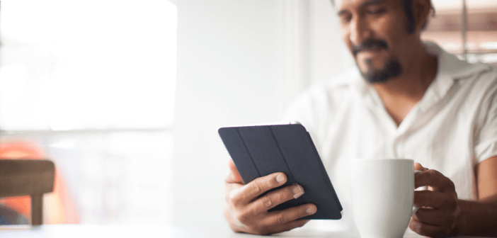 Smiling person viewing a playlist on a tablet