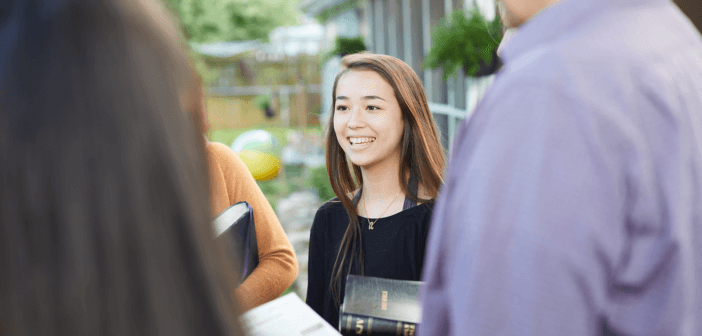 Standing outside chatting with people in the church's community