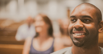 Smiling single person sitting in the pews