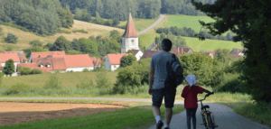 Two people walking toward a church in a small village