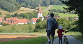 Two people walking toward a church in a small village