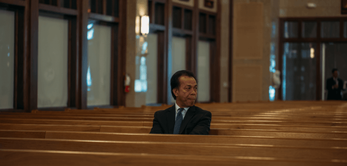 Person sitting alone in the pews