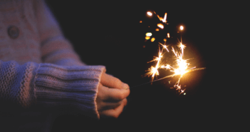 Person holding a sparkler in the darkness