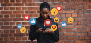 Person looking at social media on their phone while icons appear in the air around them