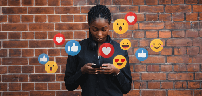 Person looking at social media on their phone while icons appear in the air around them