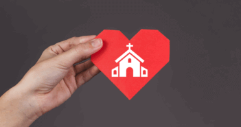 10 Ways to Care for the Emotional Health of Your Congregation During a Pastoral Transition Hand holding a paper heart imprinted with a church building