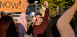 Angry protester with raised fist shouting into a megaphone