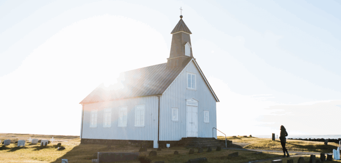 Small church with the sun peeking over the roof