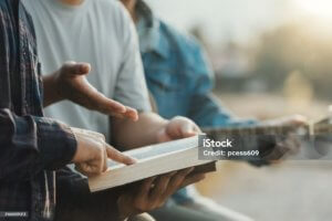 Christian Bible Study Concepts. Christian friend groups read and study the bible together in the park. sharing the gospel with a friend. followers are learning the word of God. praying to God.