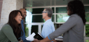 Smiling church members joyfully greeting and welcoming others at church