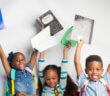 Happy children holding up their first-day-of-school supplies