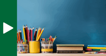 Photo of many colored pencils and books atop a desk