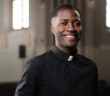 A smiling single pastor standing in the church sanctuary