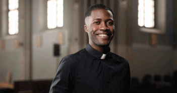 The Challenges and Opportunities of Solo Pastors A smiling single pastor standing in the church sanctuary