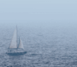 Sailboat on choppy waters in the fog