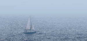 Sailboat on choppy waters in the fog