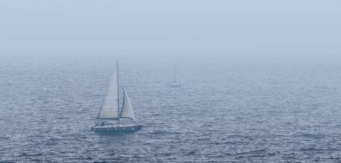 Sailboat on choppy waters in the fog