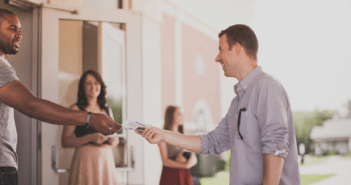 Person being greeted at church by ushers