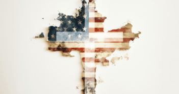 Christian cross in front of a tattered American flag