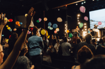 Celebration at church with balloons in the air and excited, happy people