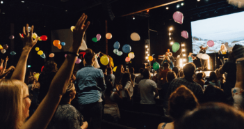 Celebration at church with balloons in the air and excited, happy people