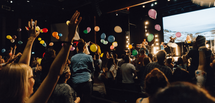 Celebration at church with balloons in the air and excited, happy people