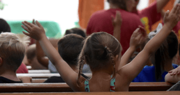 Enthusiastic children sitting in the pews during the children's sermon