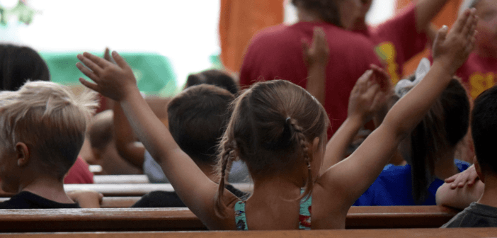 Enthusiastic children sitting in the pews during the children's sermon