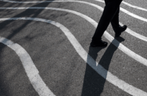 Person and their shadow walking on pavement painted with wavy lines