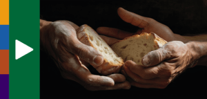 The hands of two people together holding slices of rustic bread