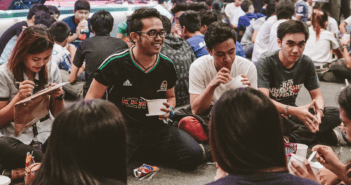 Youth sitting on the floor in circles laughing and enjoying snacks together