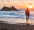 Person walking alone on the beach at sunset