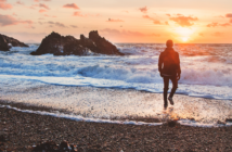Person walking alone on the beach at sunset