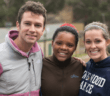 Three smiling teenagers outside on a mission trip to the country
