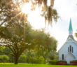 Rural church with bright sunshine filtering through the surrounding trees