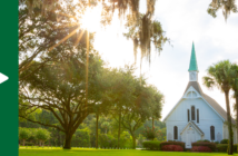 Rural church with bright sunshine filtering through the surrounding trees
