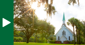 Rural church with bright sunshine filtering through the surrounding trees
