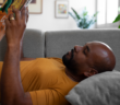 Person lying on the couch reading a book