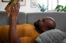 Person lying on the couch reading a book