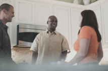Smiling people in the kitchen at an informal church gathering in someone's house