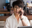 A smiling executive assistant on the phone in an office