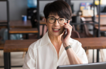 A smiling executive assistant on the phone in an office