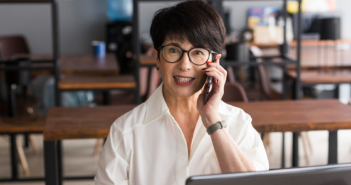 A smiling executive assistant on the phone in an office