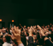 A congregation holding their hands in the air