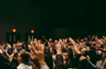 A congregation holding their hands in the air
