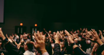 A congregation holding their hands in the air