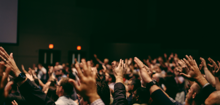 A congregation holding their hands in the air